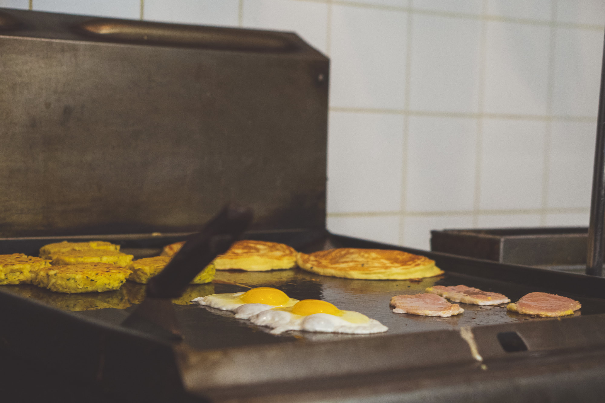 Eggs, pancakes and peameal bacon on the flat-top grill at Darlise Cafe